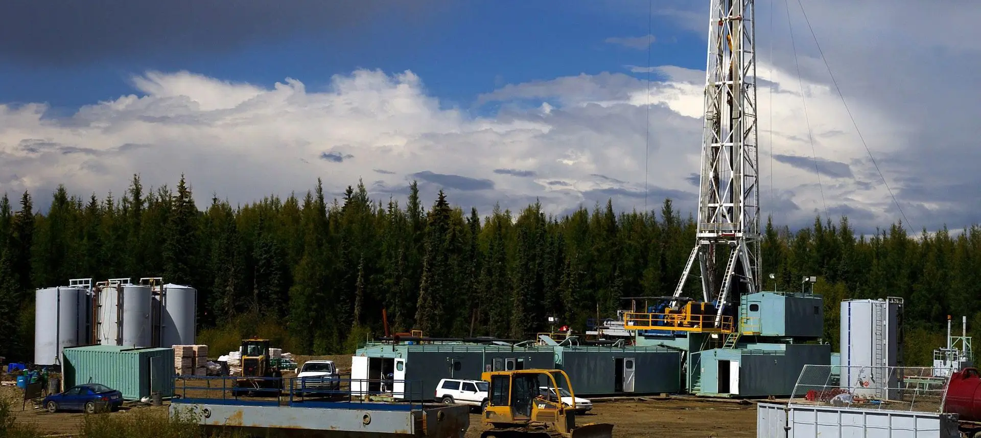 A large drilling rig in the distance with trees.