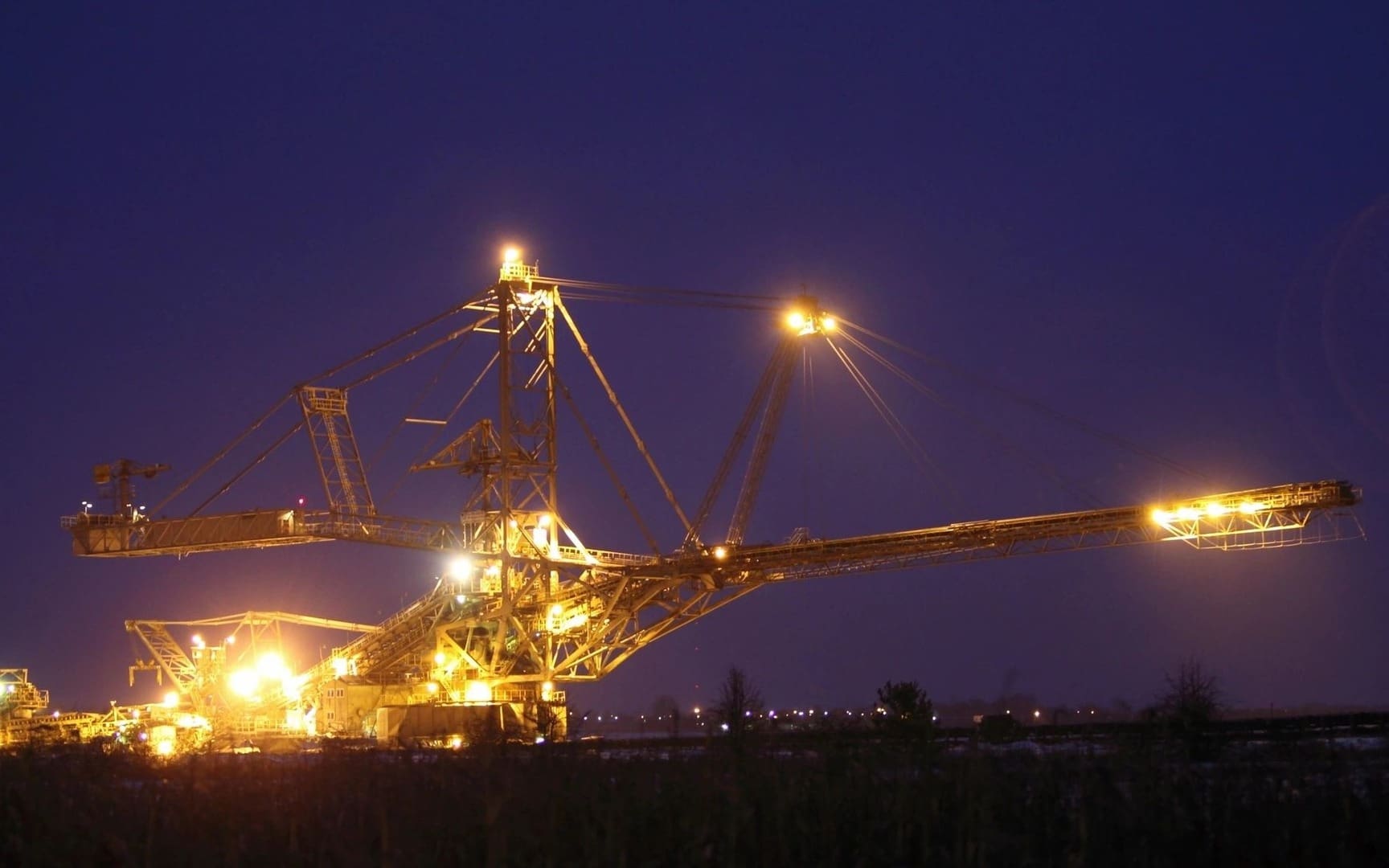 A large gold mine at night with lights on.